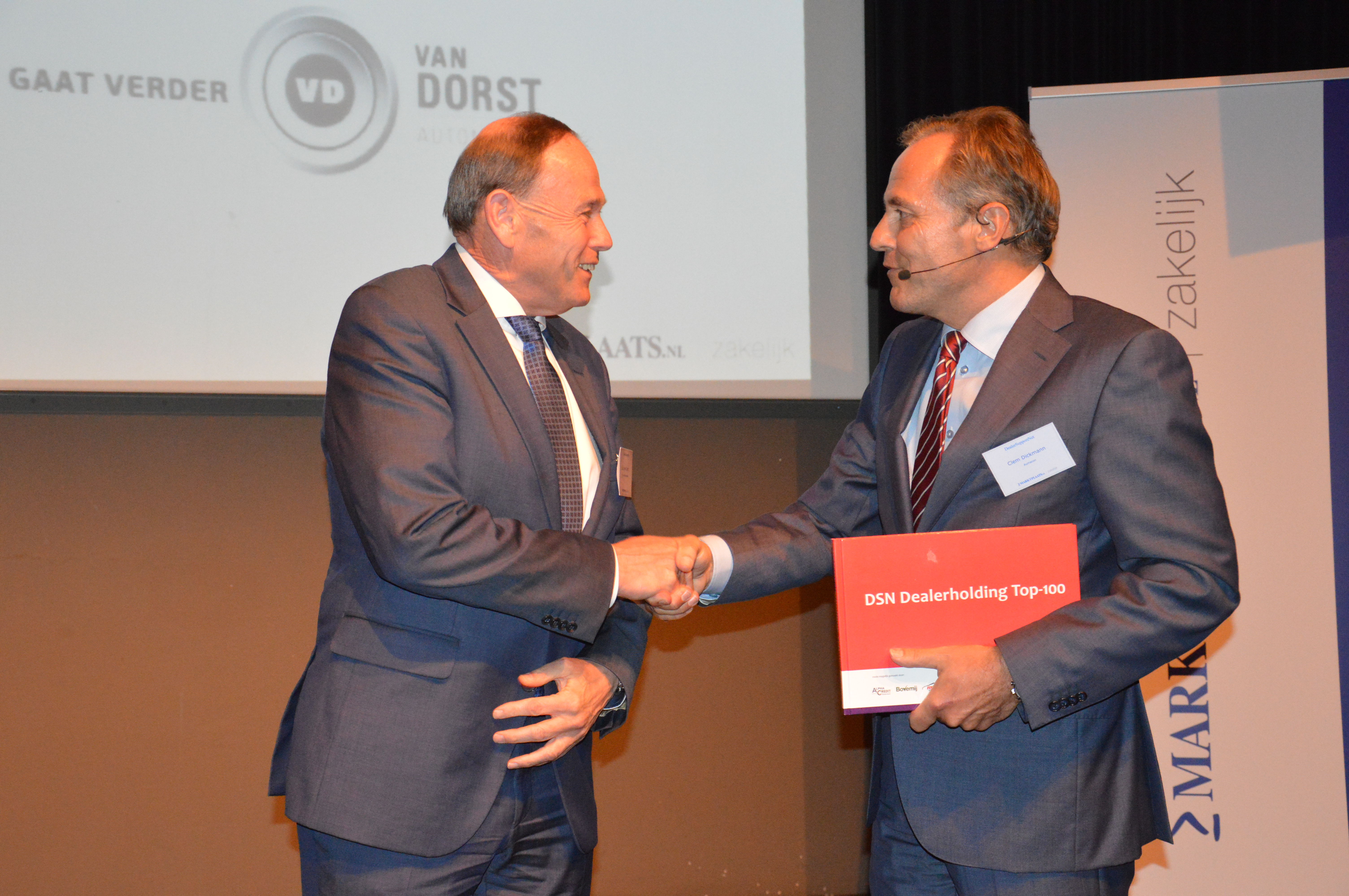 Feestelijk moment. Clem Dickmann, directeur en oprichter van DSN overhandigt het eerste exemplaar van de Dealer Top 100 aan Jacques van Dorst. Diens succesvolle dealerbedrijf staat dit jaar voor het laatst in de Dealer Top 100. Van Dorst heeft het verkocht aan Louwman Retail.
