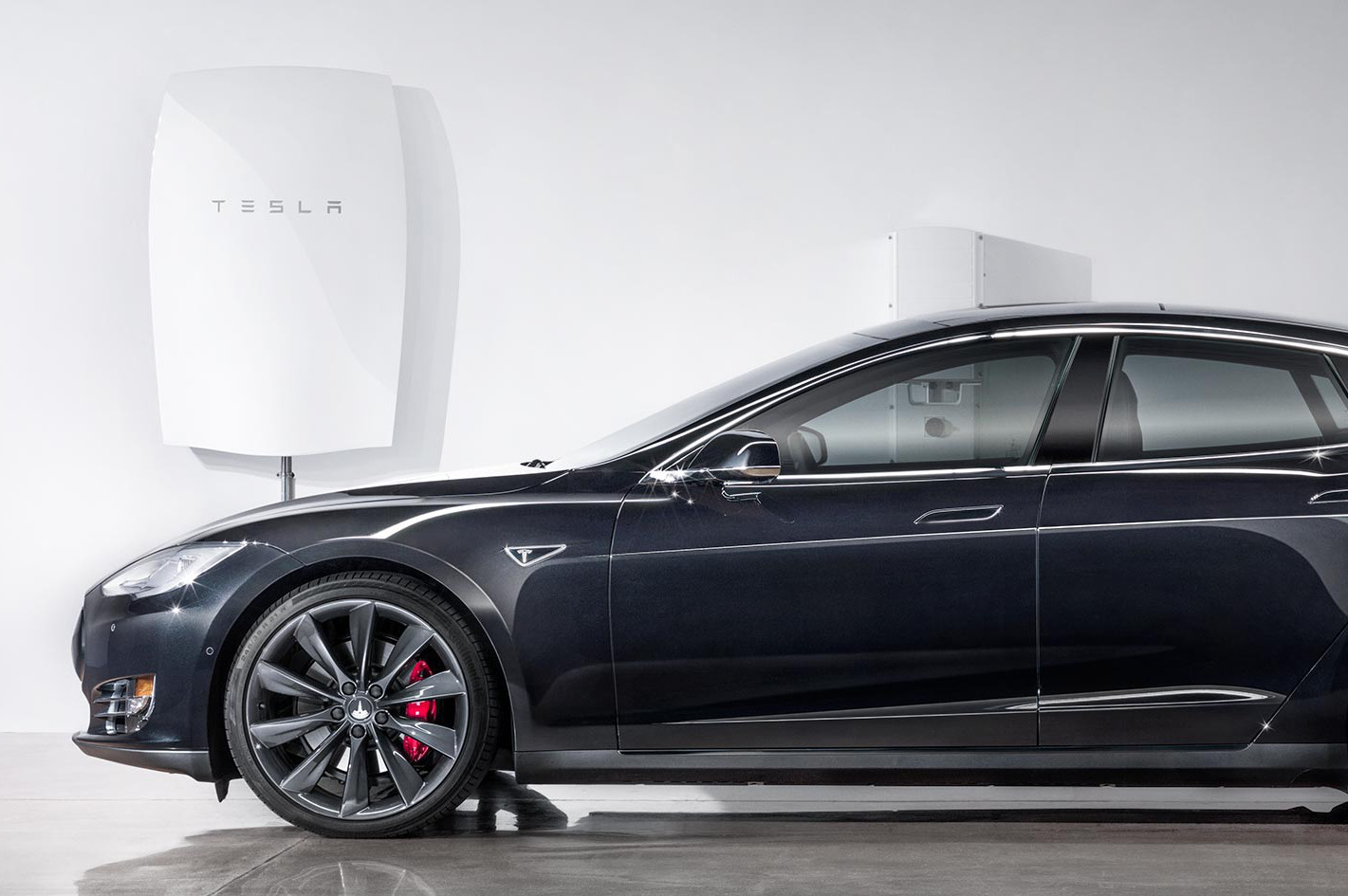 Thuisgarage van de toekomst? De Powerwall (linksboven) is goed voor 7 kWh, de Model S voor 85… (Foto: Tesla)