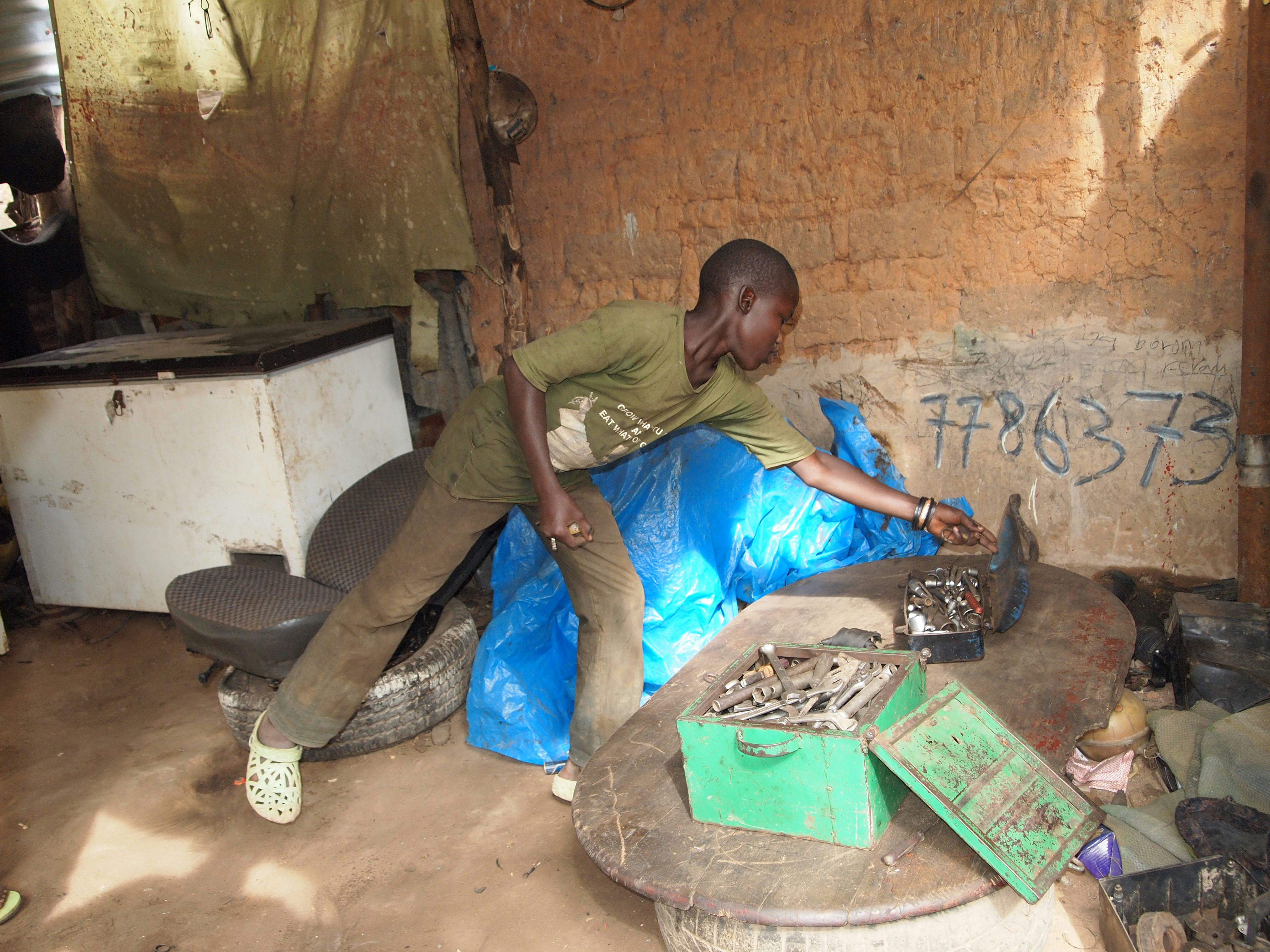 Heel normaal in Gambia, geen geld voor school, ga maar werken. Zo is Ousman zelf ook begonnen. Oh, en die kist met gereedschap is goud waard.
