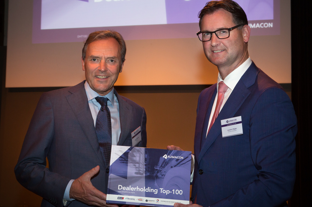 Directeur Clem Dickmann overhandigt het eerste exemplaar van de nieuwe Aumacon Dealerholding Top 100   aan Laurens Stigter, directeur van nieuwkomer in de Top 10, Wensink Automotive.