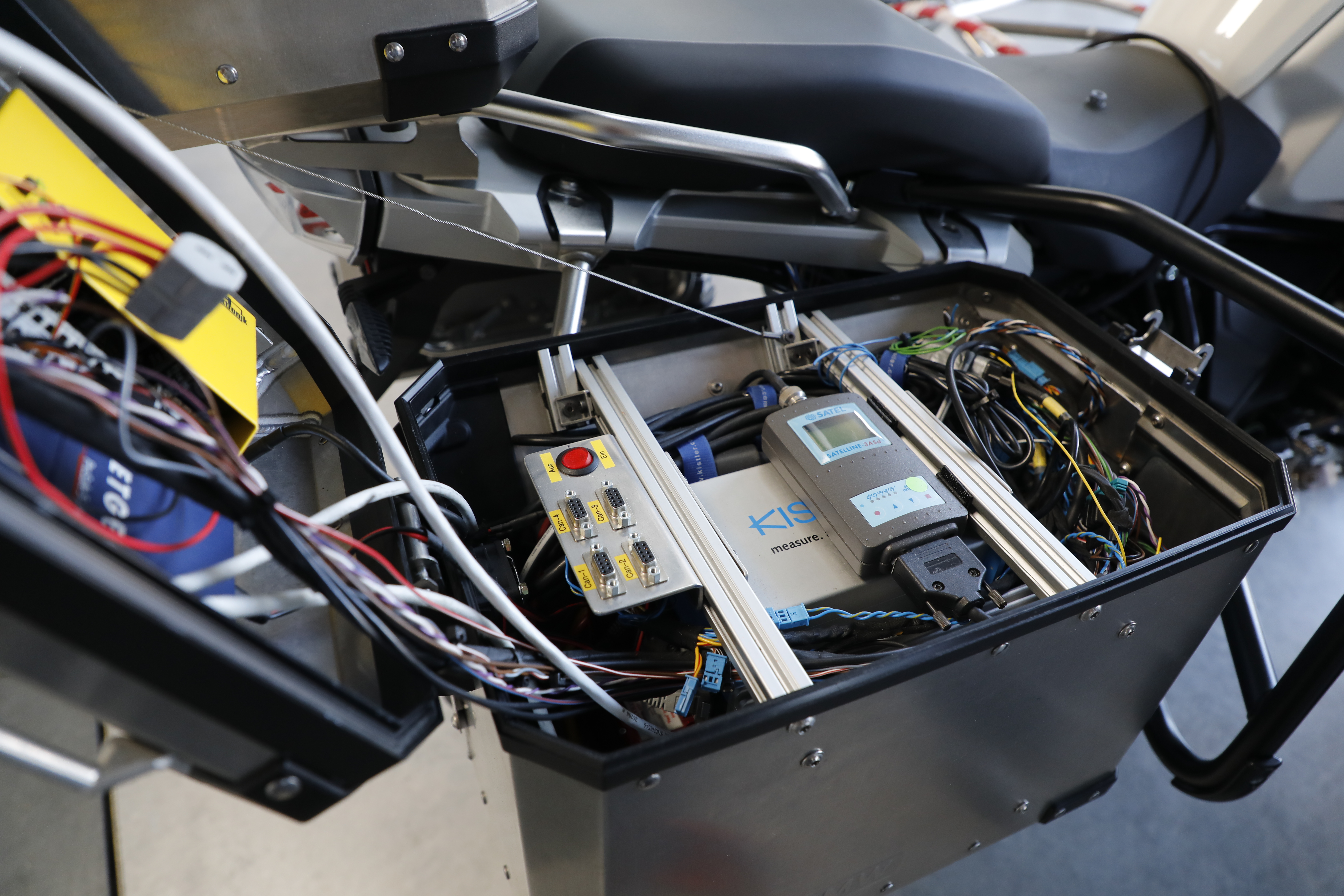 Voor een zelfrijdende motorfiets zijn nu nog koffers vol meet- en regelapparatuur nodig. Straks moet dat allemaal compact in de motorfiets verwerkt zijn.