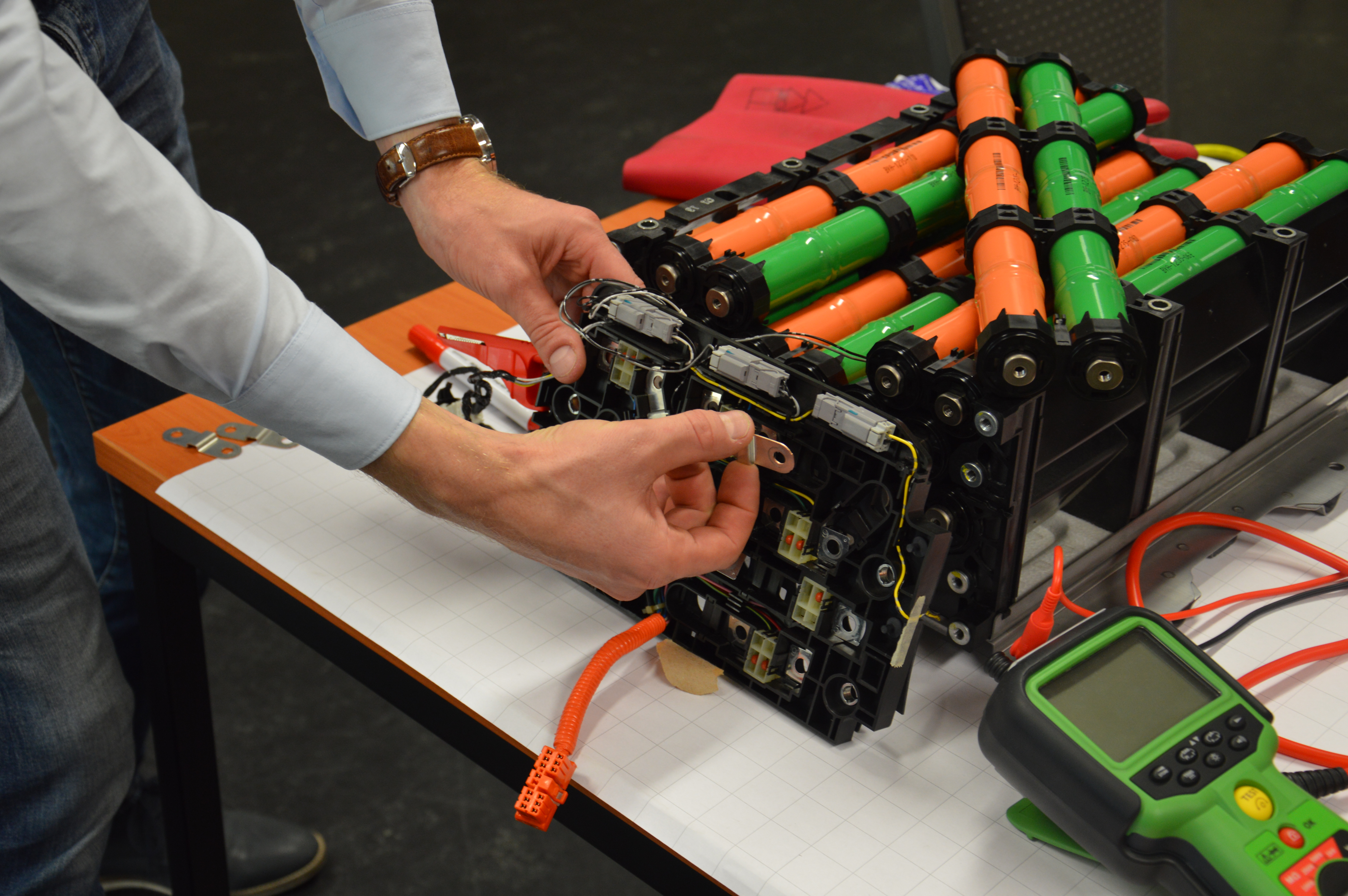 Als ‘ev Vakbekwaam Persoon’ kun je meer dan je denkt. De batterij van een Honda Civic Hybrid bestaat uit elf van deze modules. Als er een stuk is, kun je die uitwisselen. Via deze plaatjes zijn ze in serie geschakeld. De veiligheidschakelaar onderbreekt die schakeling zodat aan de ene pool een groep van vijf en aan de andere een groep van zes modules ontstaat.    