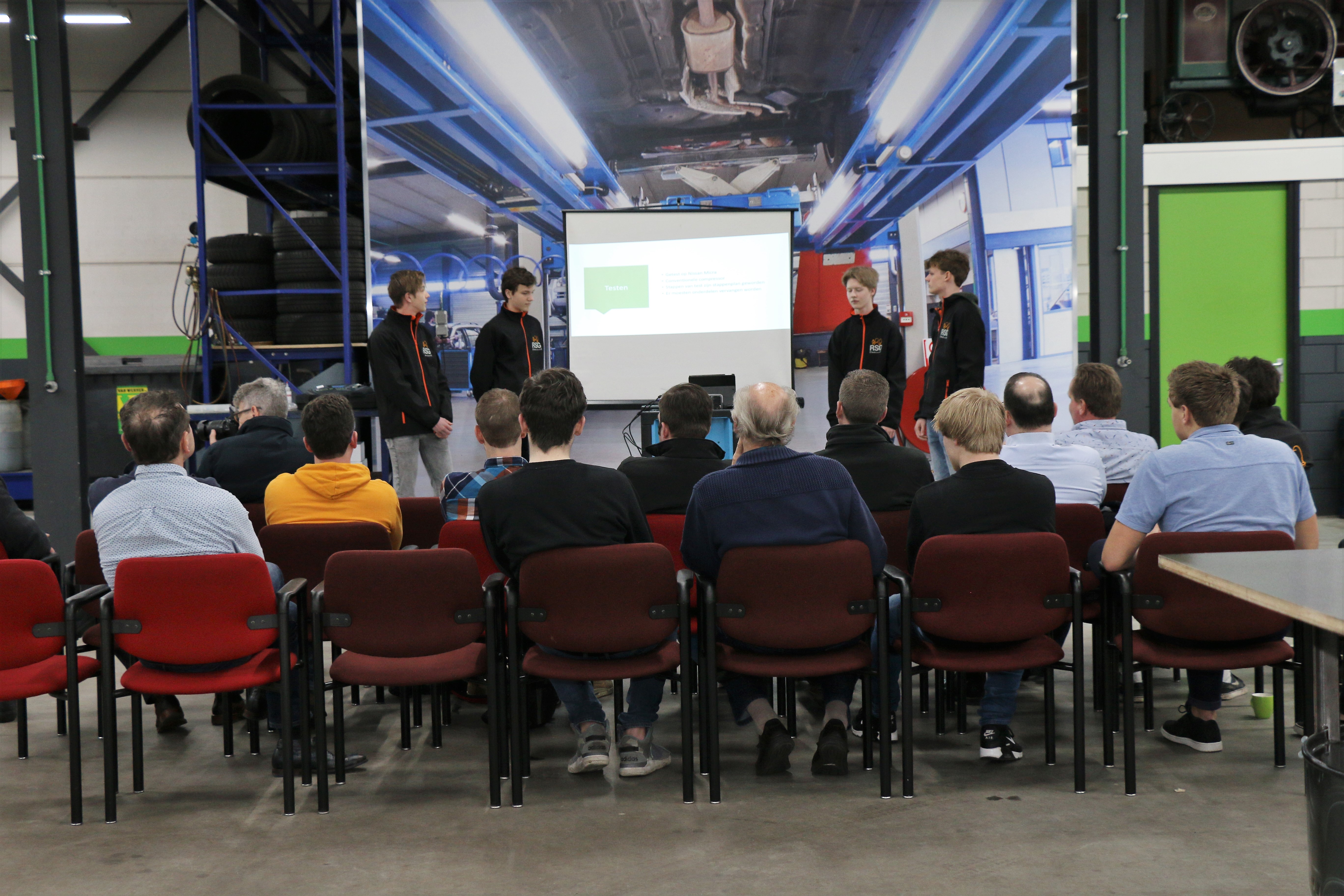 Vier scholieren presenteren hun werk, auto-aircodeskundigen van onder meer Denso, Dometic, Gasco, Unicorn en Texa luisteren ademloos toe. (Foto: George Hertel)