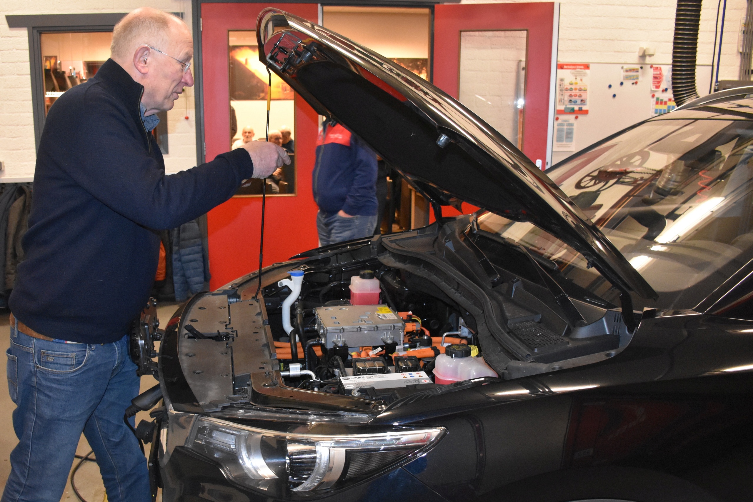 Brandweerkazerne Staphorst. Een rode truck heeft ruimte gemaakt voor een zwarte SUV en de vroegkomers onder de Zwolsche ATC-leden werpen vast een blik onder de motorkap.