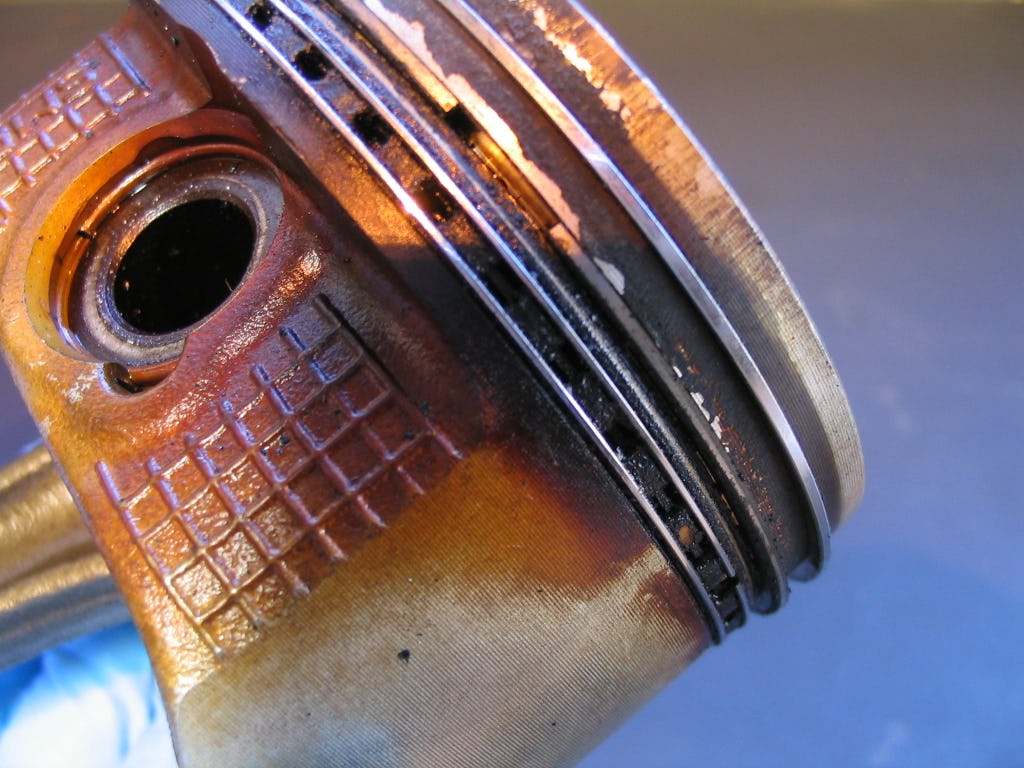 Een vervuilde zuiger met lakafzetting en vastzittende olieschraapveren. Deze is te reinigen door te flushen. Het resultaat zie je op de volgende foto.