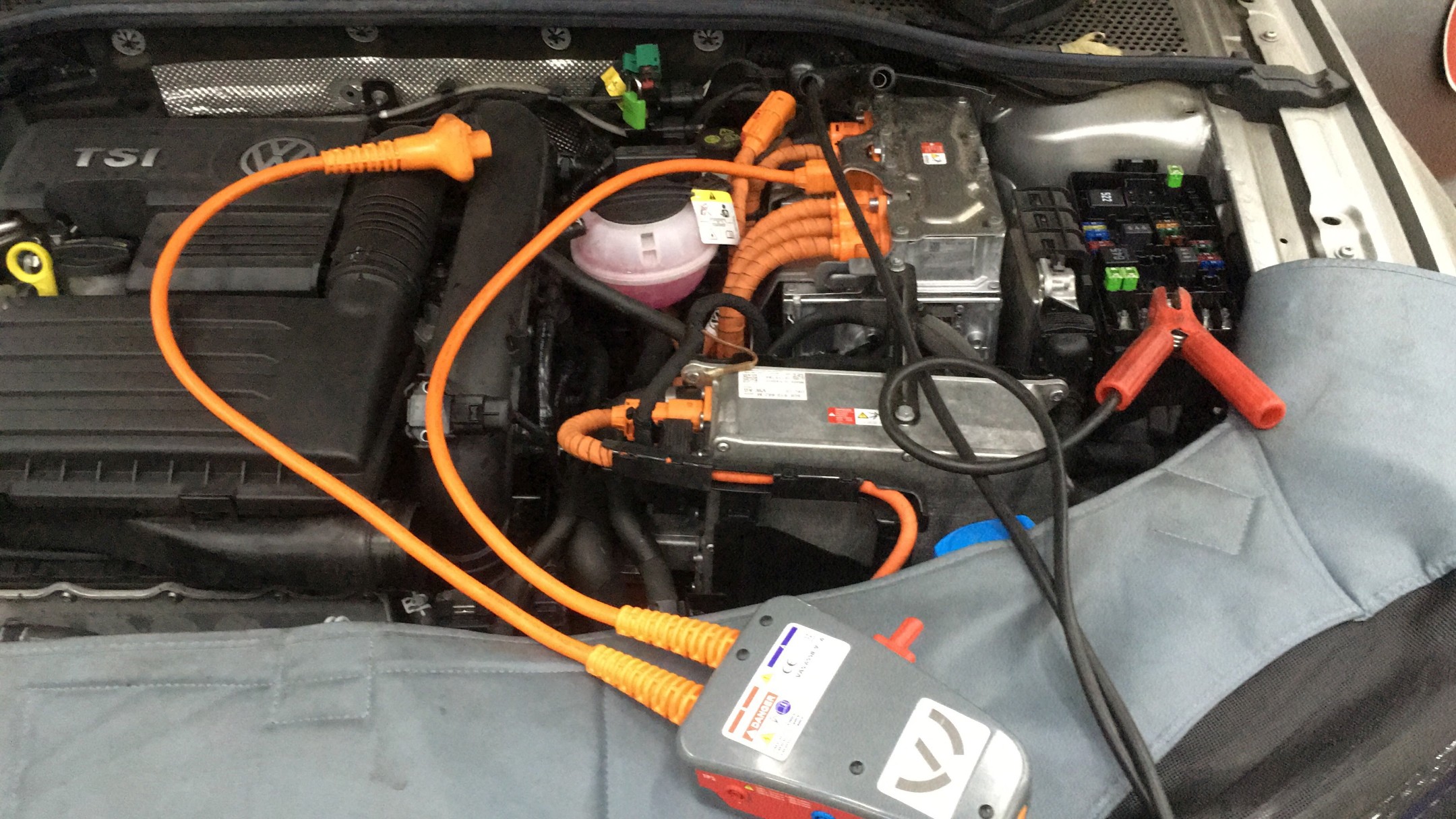 Dit is een vrijgeschakelde hoogvoltinstallatie van een Passat. Met het grijze kastje kun je diverse metingen verrichten en de spanning controleren.