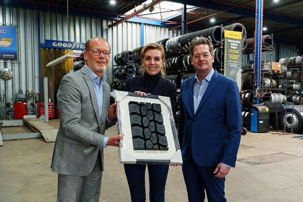 Ron van der Jagt (links), voorzitter VACO, overhandigde de staatssecretaris een ingelijst bandenprofiel. Rechts Carlo Hijzen directeur van Roline en vicevoorzitter van VACO.