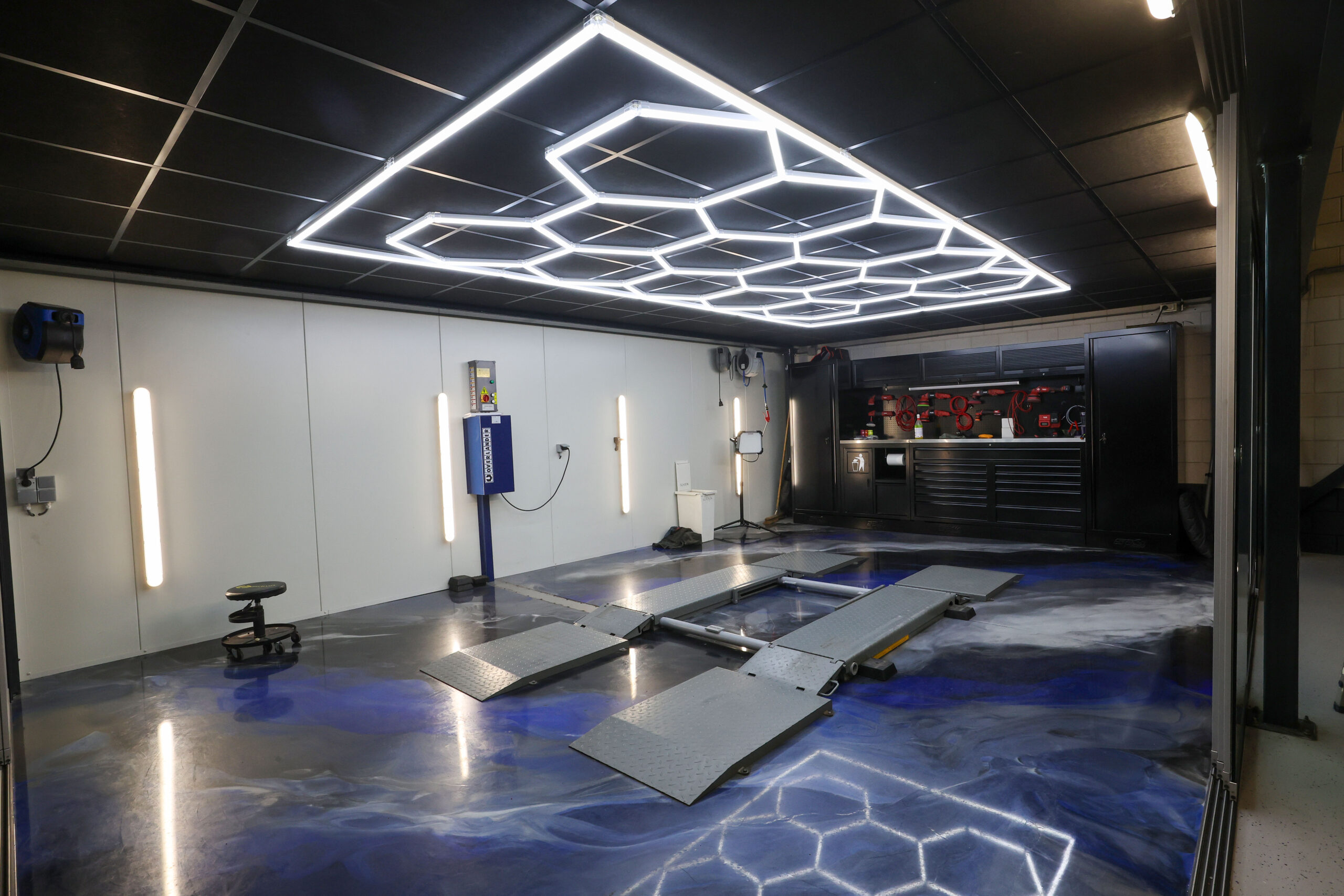 In deze ruimte brengen de twee fulltime detailers auto’s in mooier dan nieuwstaat. De helderwitte hexagonale ledverlichting helpt om een perfect eindresultaat te bereiken. De polijstmachines zijn van Flex Tools en de werkbank is van SP Tools. De unieke gietvloer is van kunstenaar Rivadé Arbre.