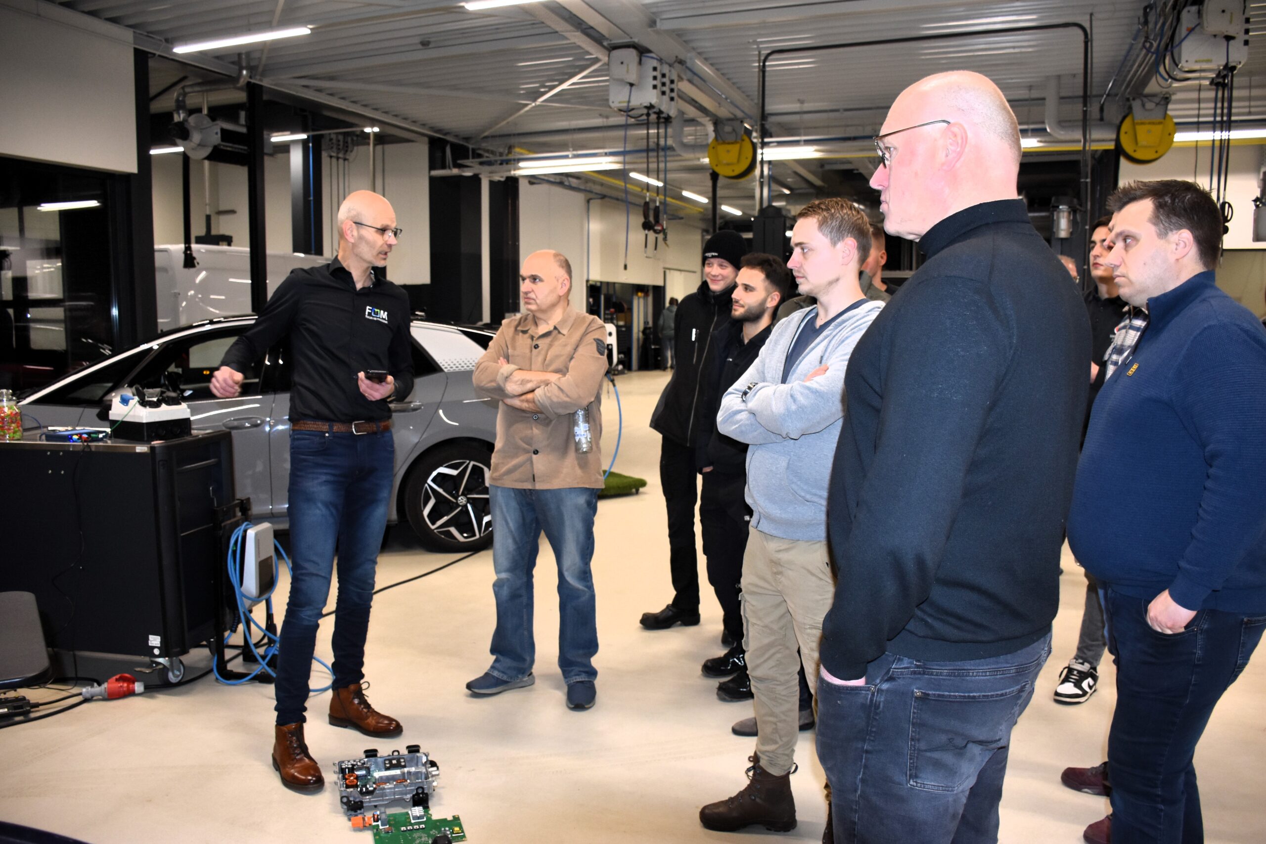Wat doet zo’n OBC precies én hoe doet hij dat? FOM-trainer Leander Engelbertink legt het uit aan Twentse autotechnici.