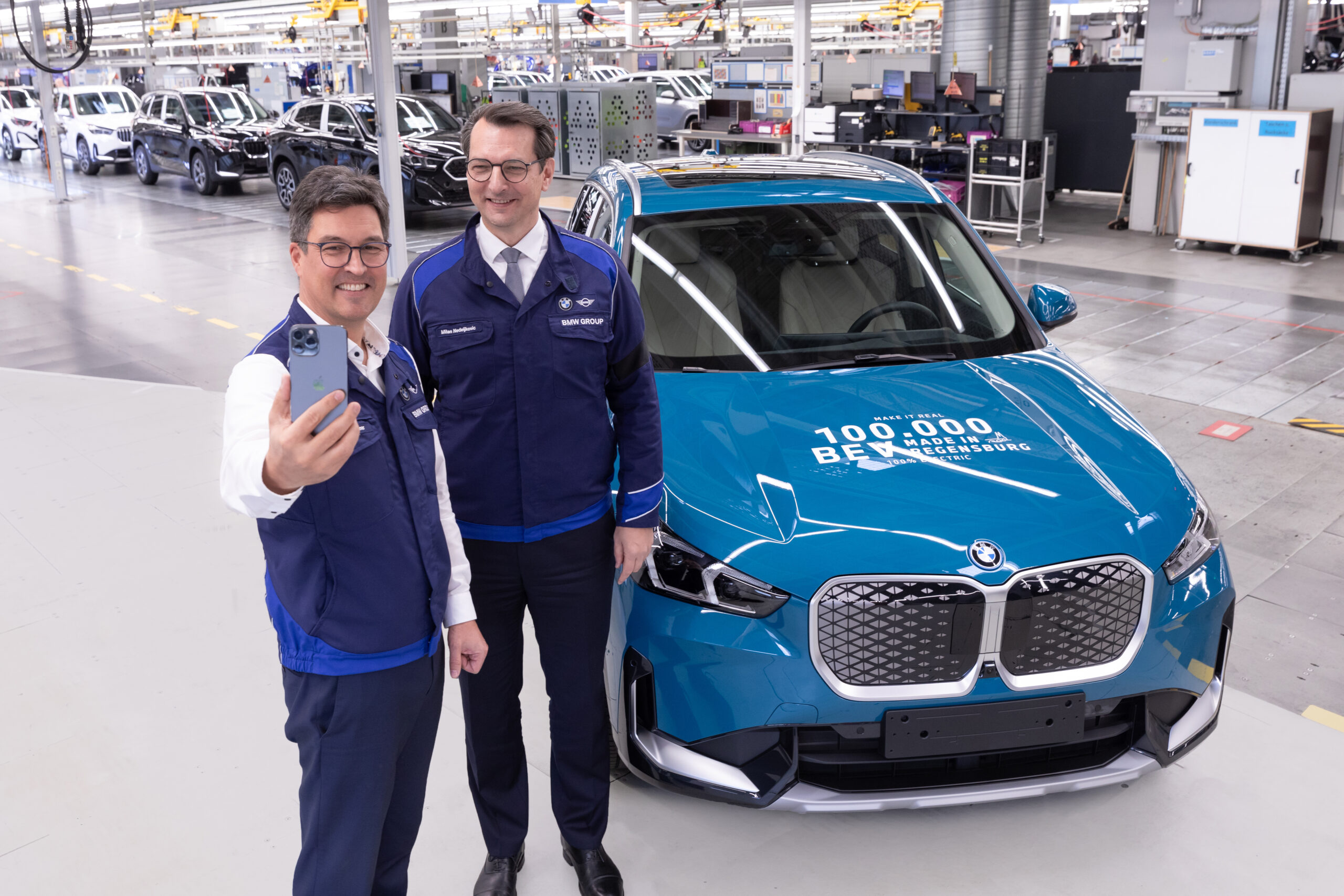 Vooral de zakelijk markt koopt e-auto’s. ‘Luxemerken’ als BMW en Mercedes scoren goed. Topper bij BMW, de elektrische iX1. Hier een als honderdduizendste e-auto uit de Regensburg fabriek, eind 2024.