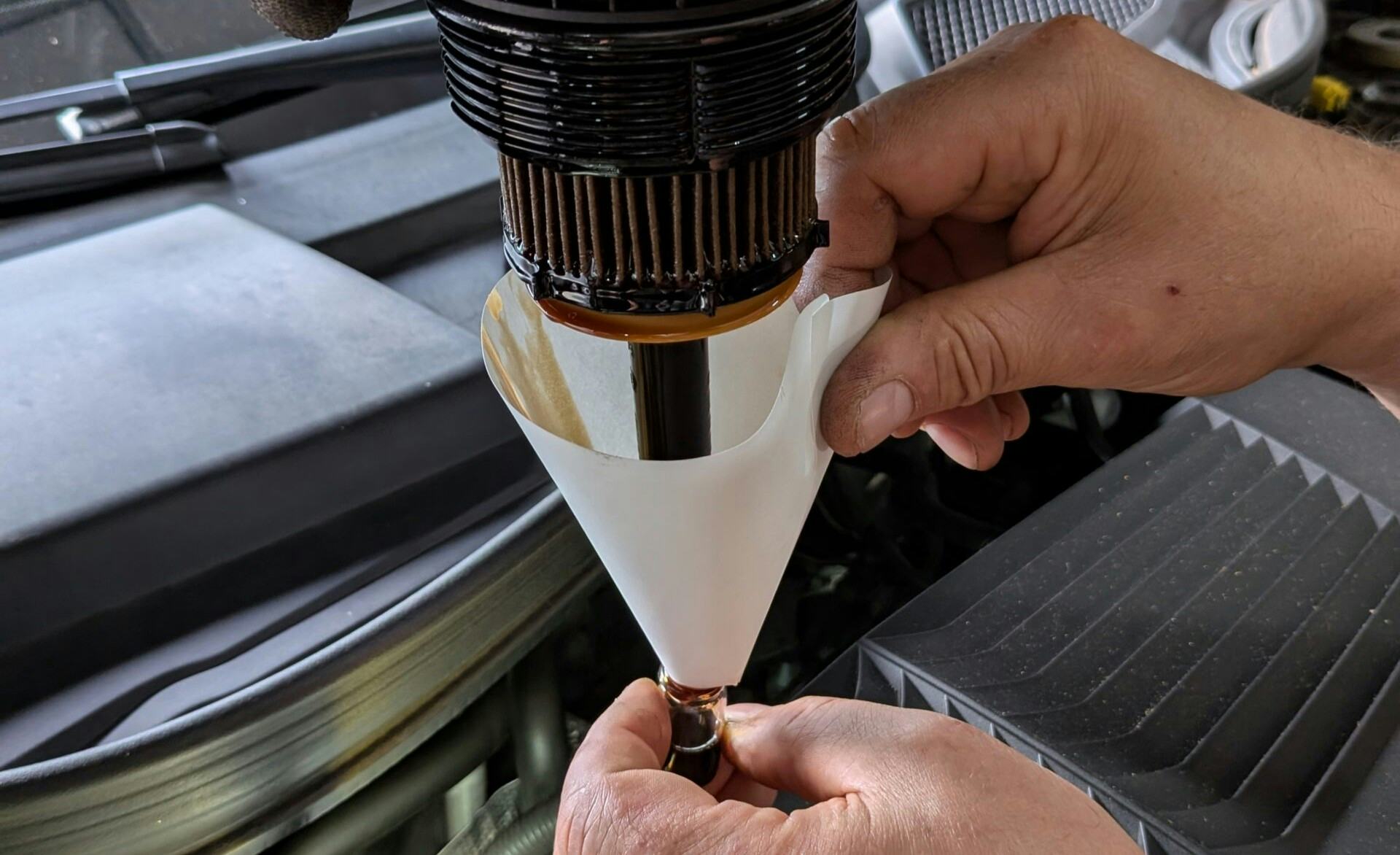 Geen Peilstok? Arnold Tip en zijn collega vangen druppels vanuit het gedemonteerde oliefilter.