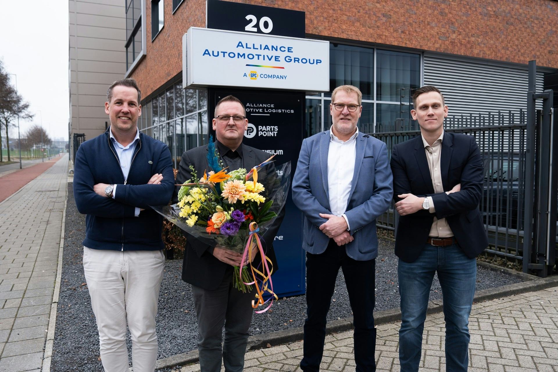 De heren van Niterra (midden) nemen dankbaar de titel Supplier of the Year 2025 en bloemen in ontvangst van AAGB. Foto: Alliance Automotive Group Benelux